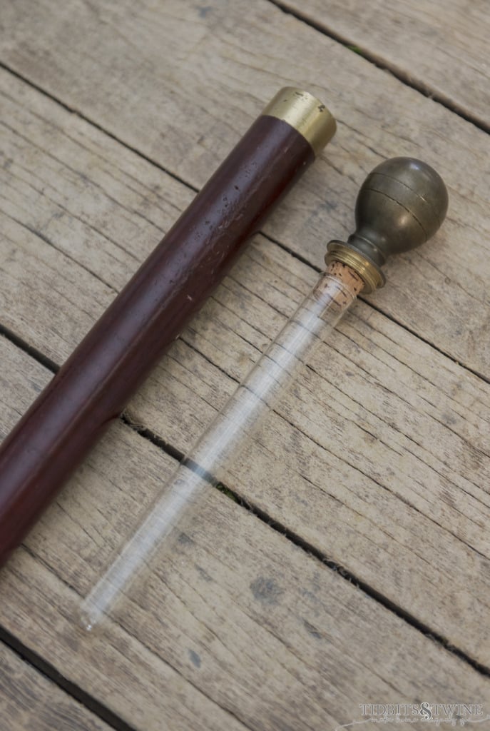 closeup showing antique wooden gadget cane with flask in the handle