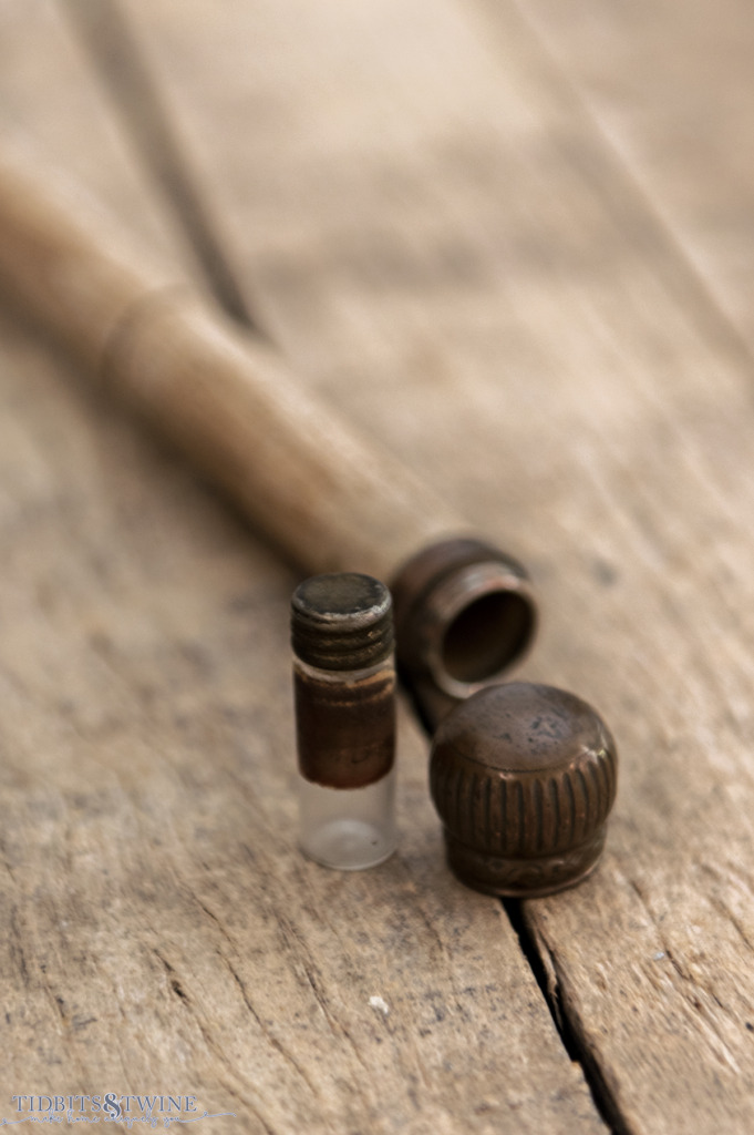 closeup of antique gadget cane with top unscrewed and little glass bottle to hold ink