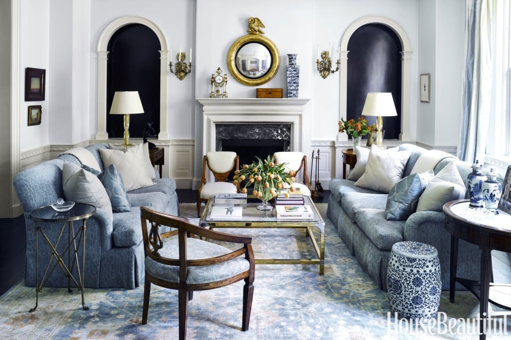 blue and white traditional living room with gold mirror above the fireplace