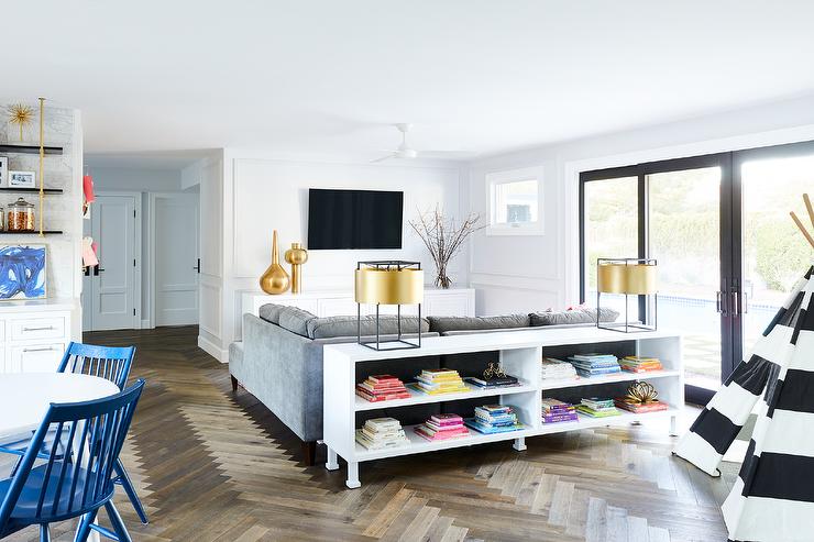 low white bookcase behind a gray sofa in a contemporary living room