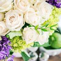 looking from above white roses with purple stock and green hydrangea with limes in an ironstone bowl beneath