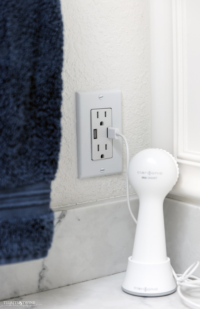 Closeup of wall outlet with USB ports in a bathroom with carrera marble
