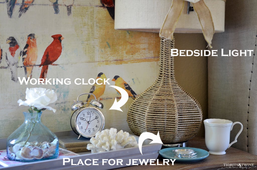 brown nightstand with lamp tray jewelry dish and clock on top with bird art in background