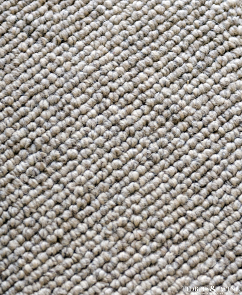 closeup of beige wool loop carpet showing variance in the loops due to handmade item