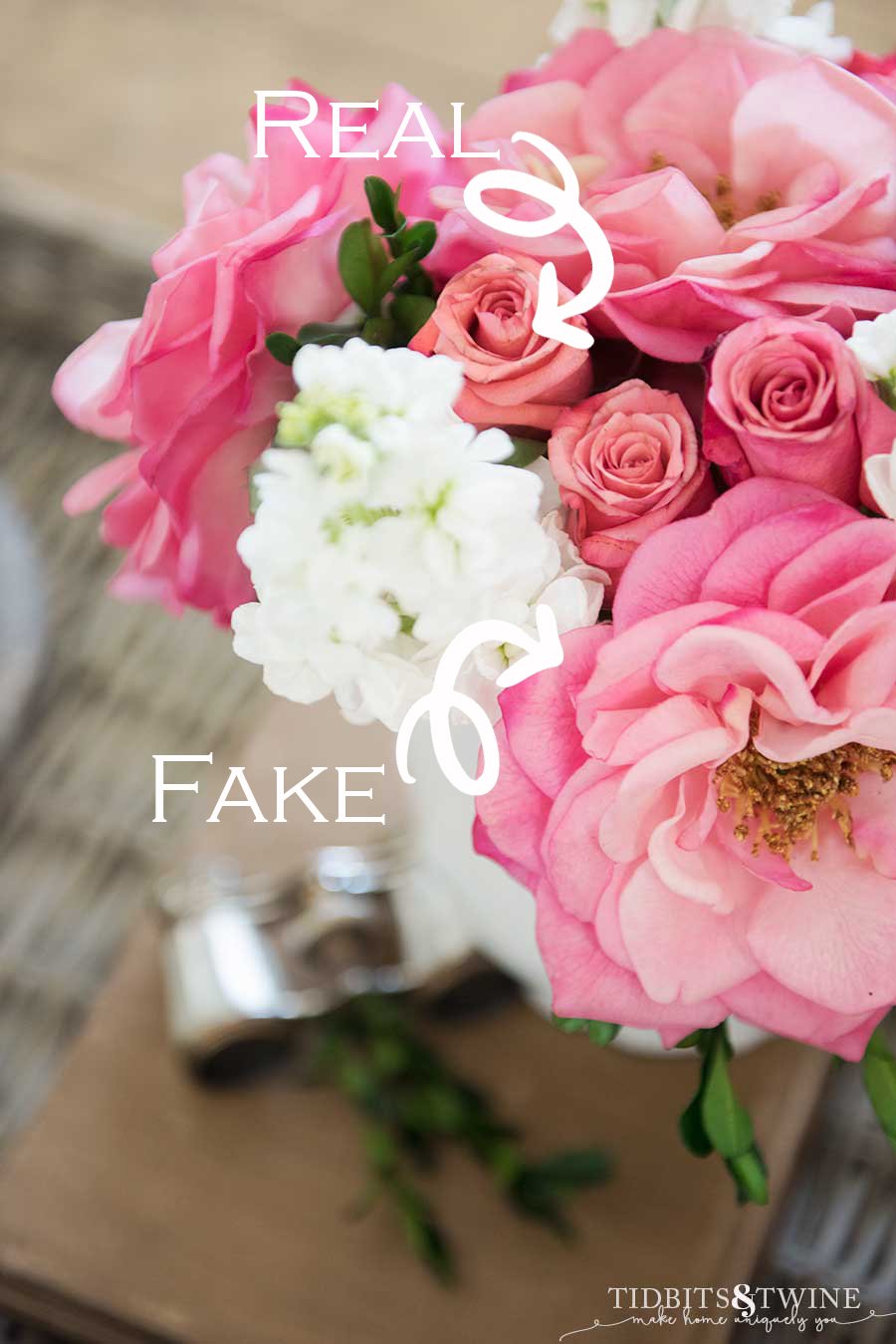 bouquet of pink rose buds and pink fake flowers with white stock and boxwood with opera glasses in the background