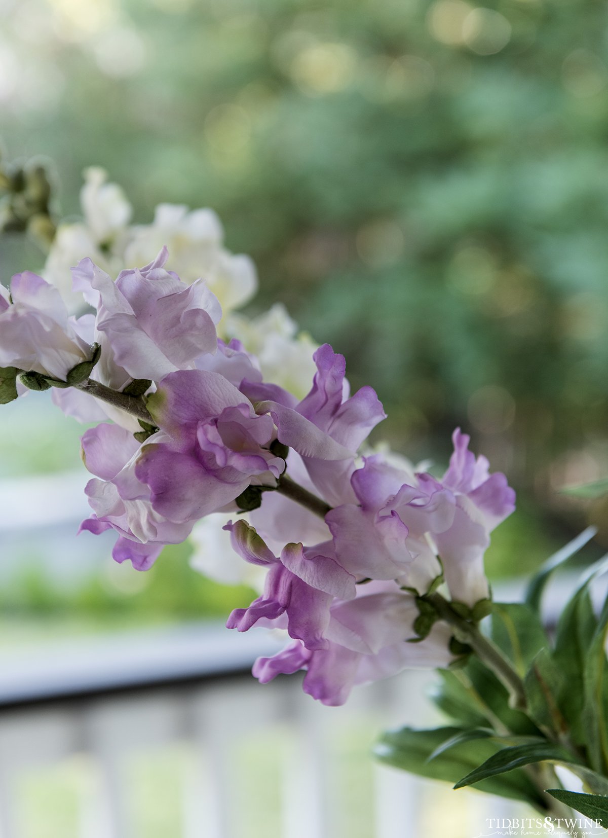 closeup of fake purple snapdragons showing the flowers on a long green stem