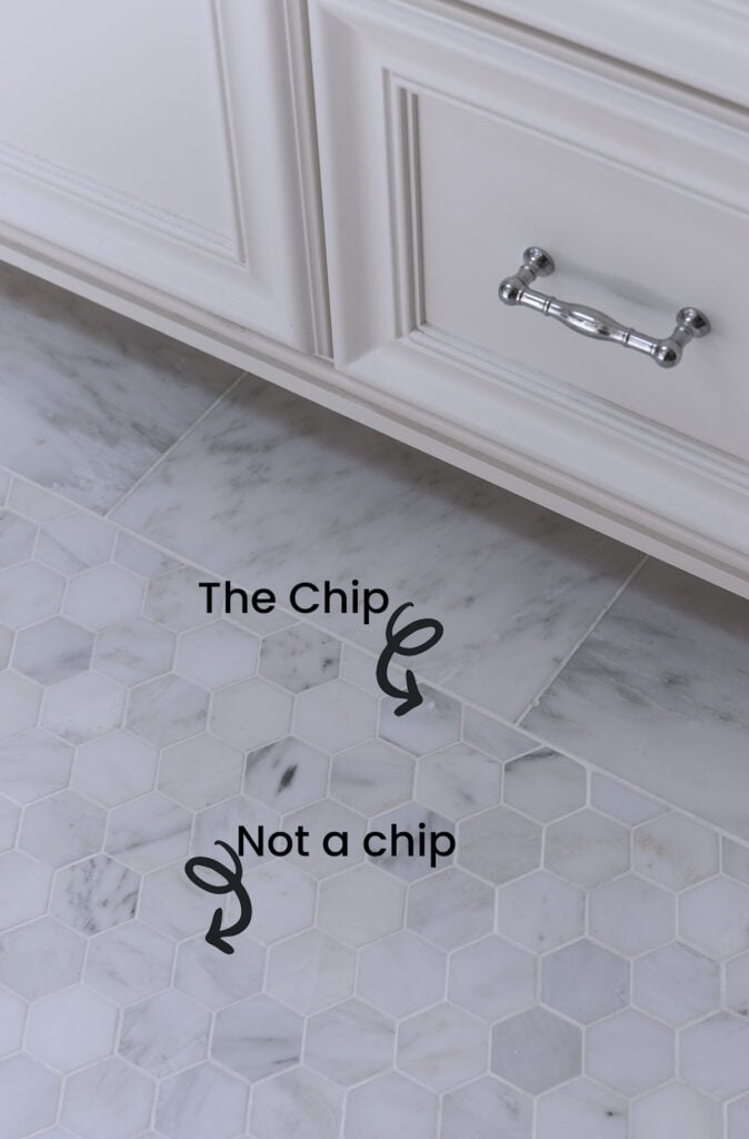 bathroom floor with two inch hex marble tile next to custom white bathroom vanity showing chip in tile