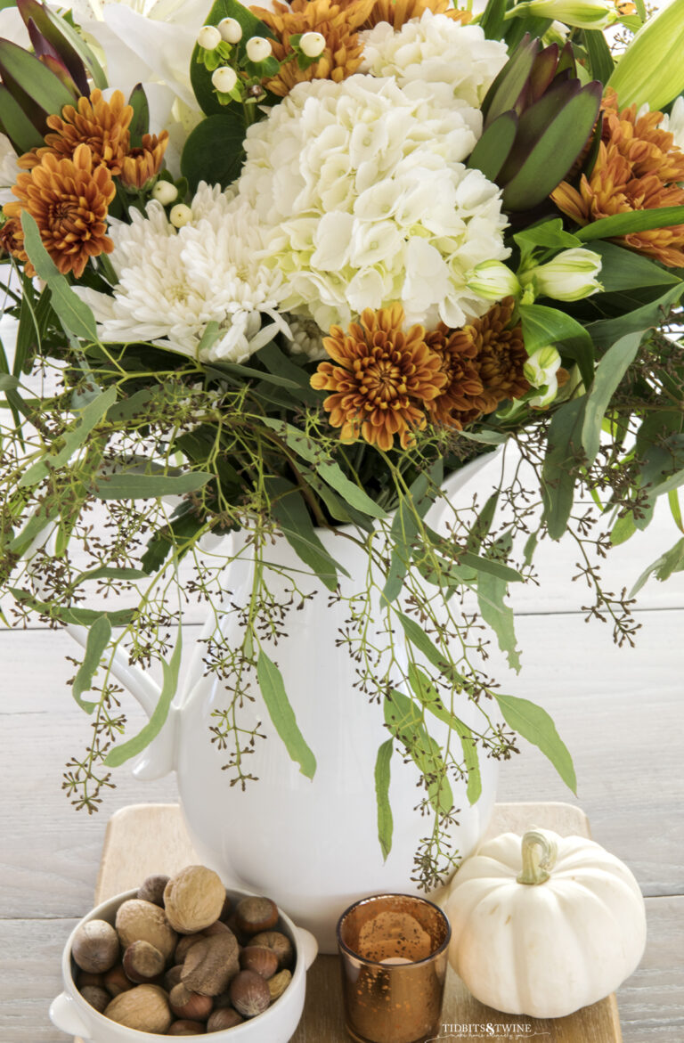 top down view of flower arrangement with white hydrangea and rust chrysanthemum in white pitcher