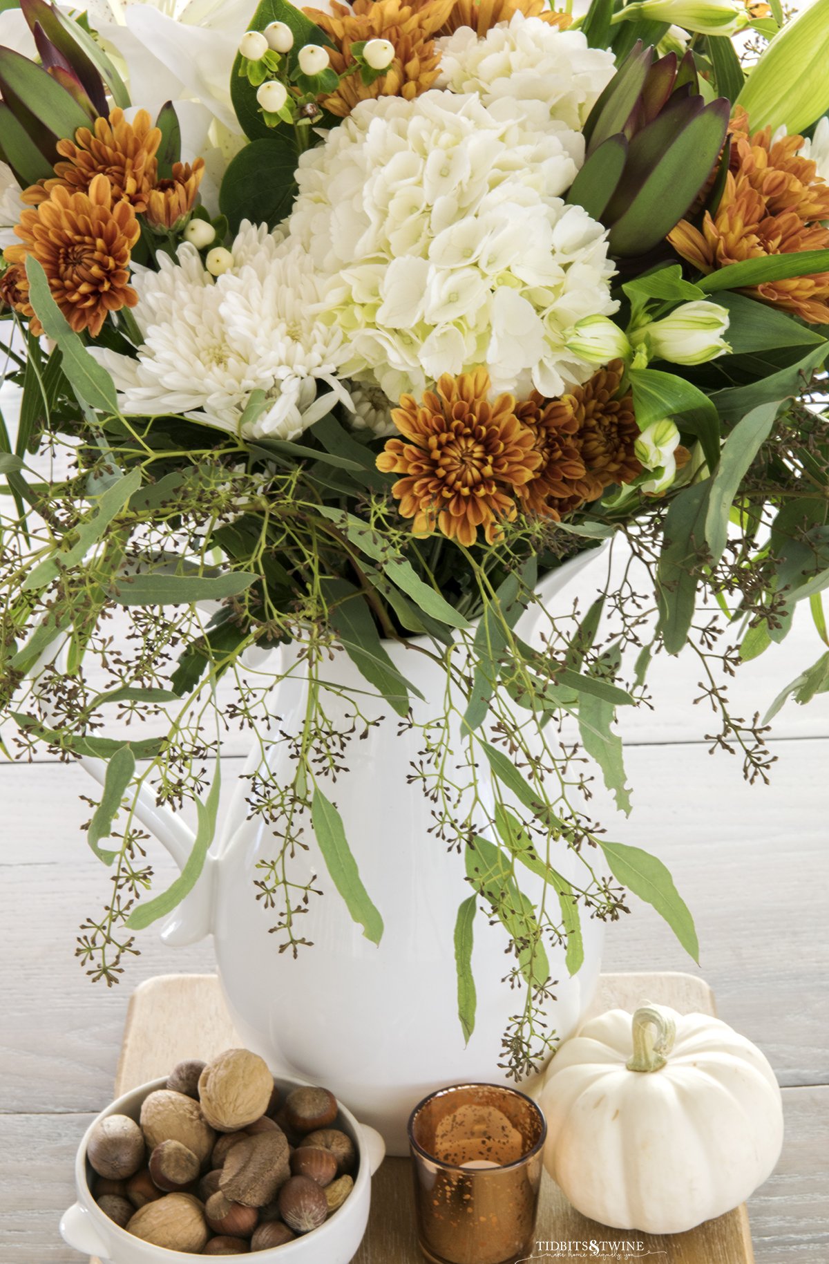 top down view of flower arrangement with white hydrangea and rust chrysanthemum in white pitcher 