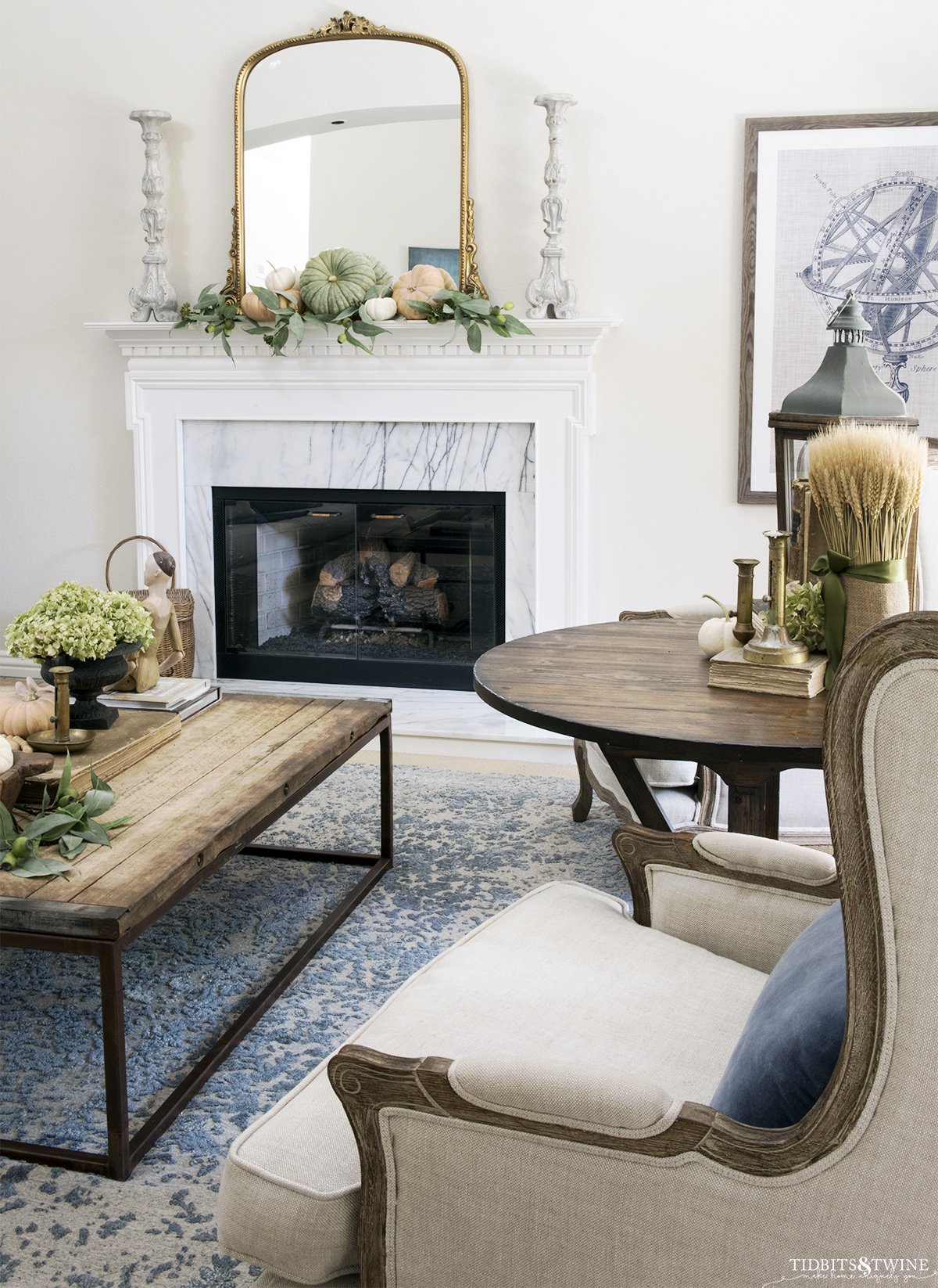 french living room with fireplace decorated for fall and linen wingback chairs