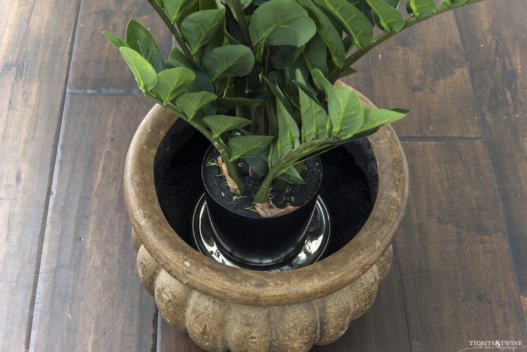 fake zz plants on silver stand inside brown plastic pot