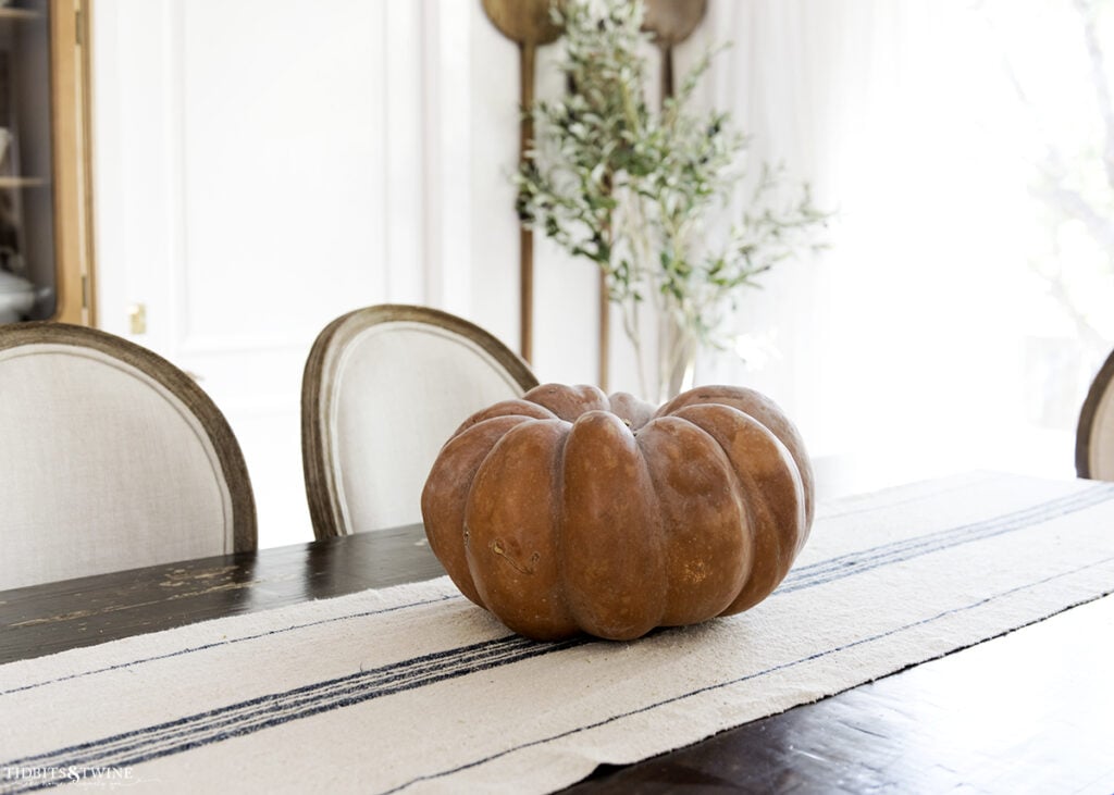 French dining room with blue grain sack table runner and terracotta pumpkin on center of table