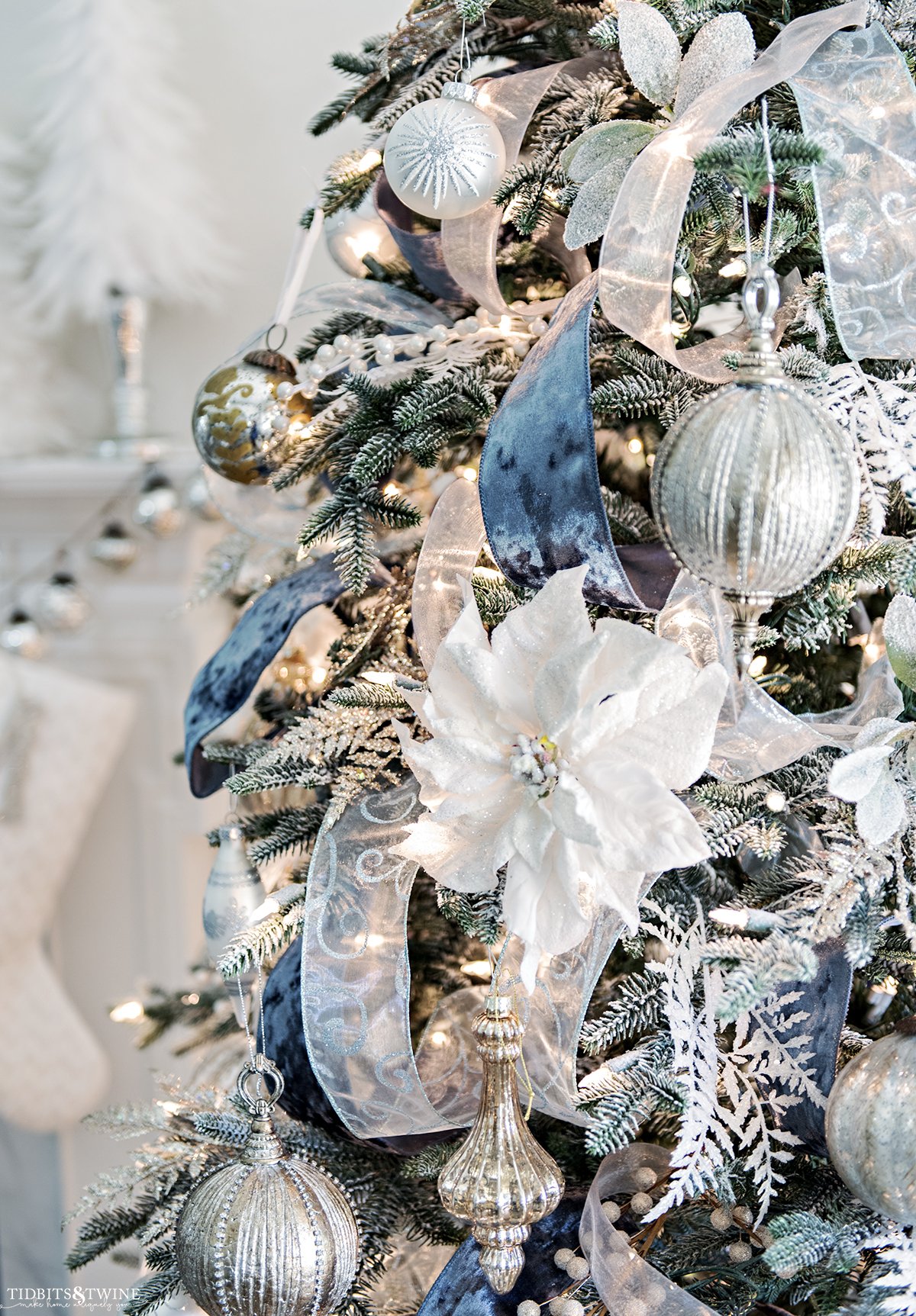 artificial flocked artificial christmas tree decorated with blue ribbon