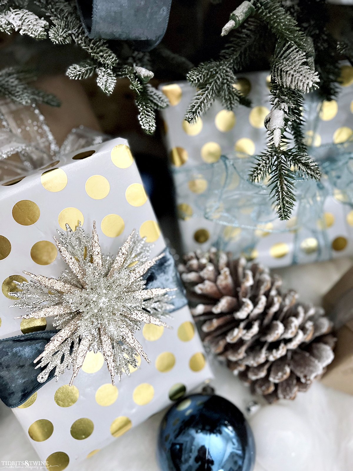 closeup of white Christmas present with gold polka dots with blue ribbon tied around