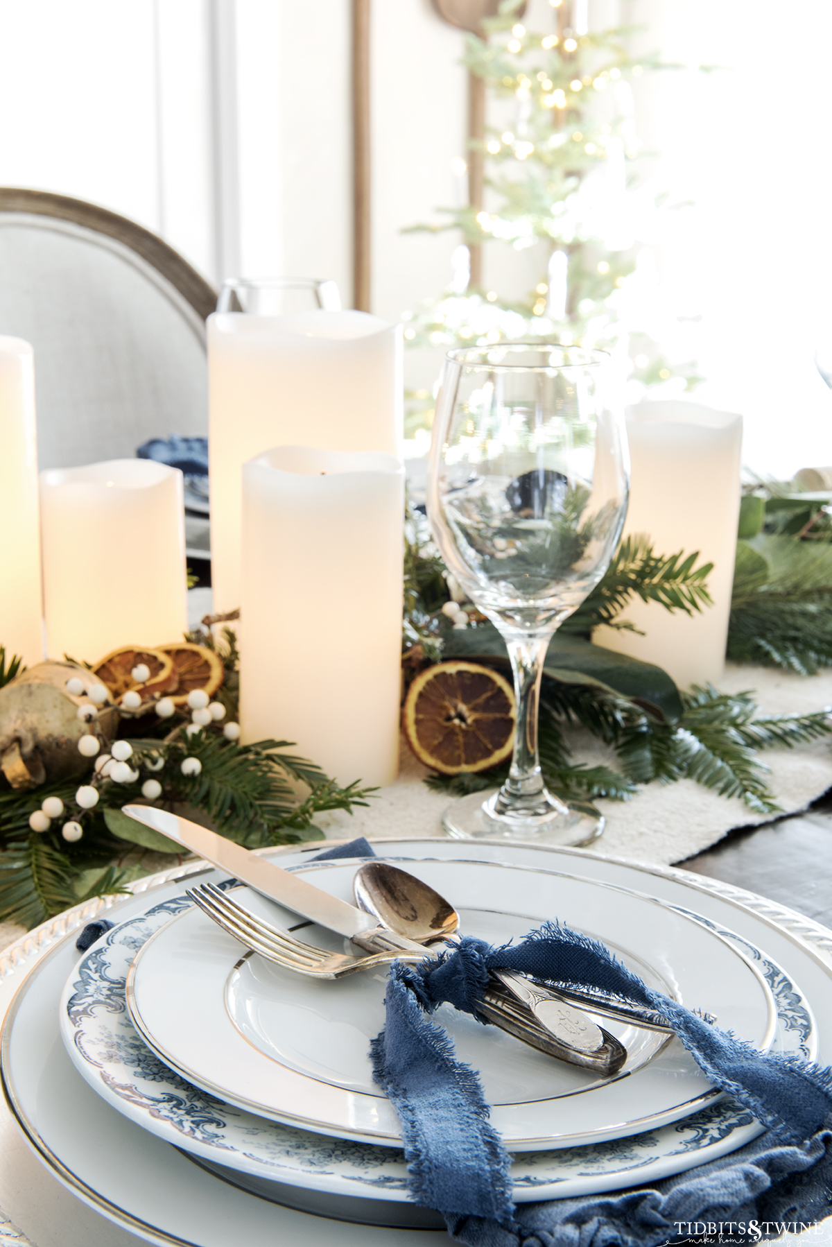 christmas place setting in blue and white with vintage flatware tied with blue velvet ribbon