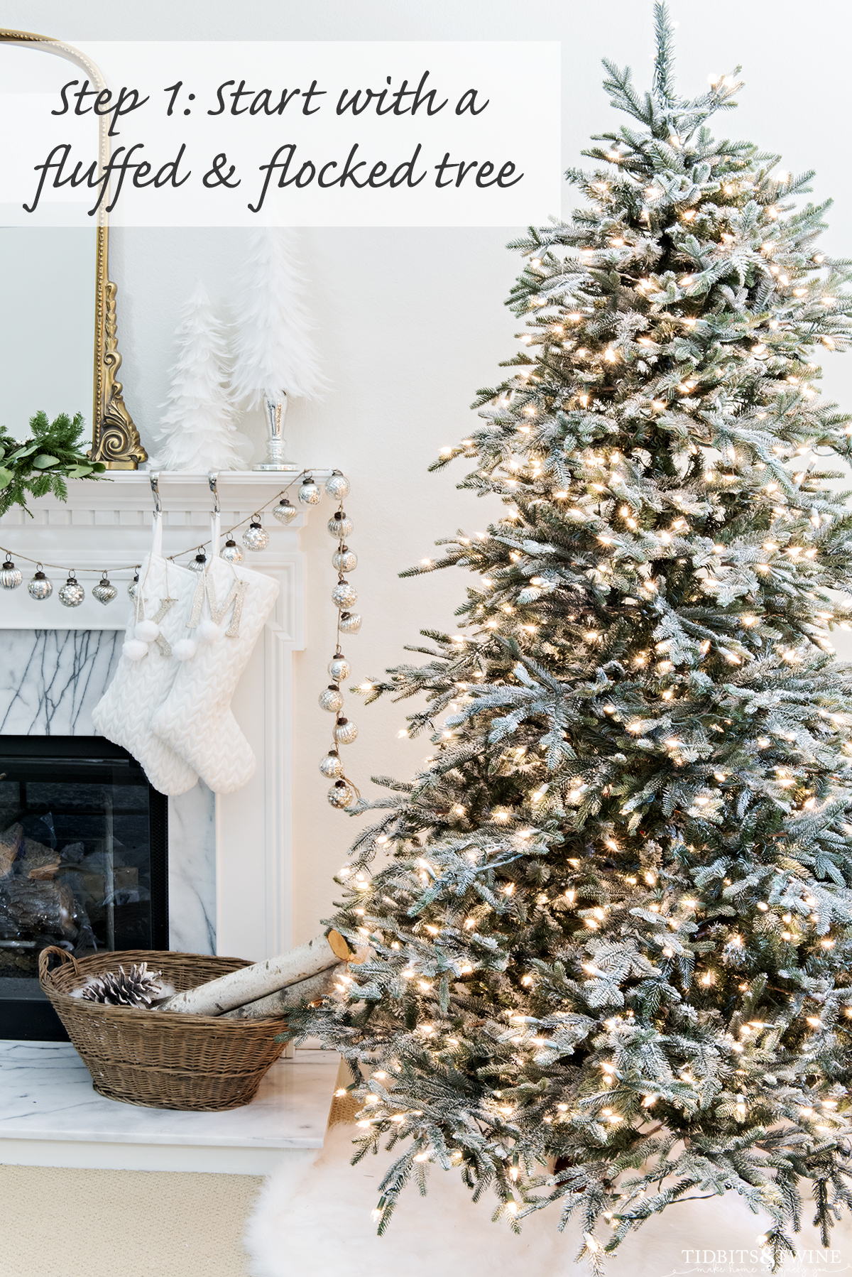 DIY flocked artificial christmas tree next to white fireplace with mercury garland and basket of wood
