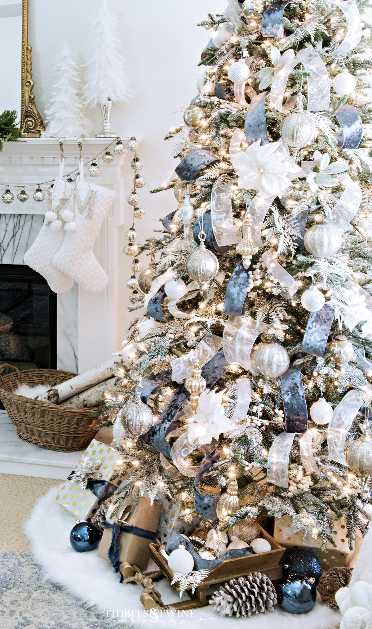 blue and white french christmas tree with fireplace mantel in background and presents and ornaments around base