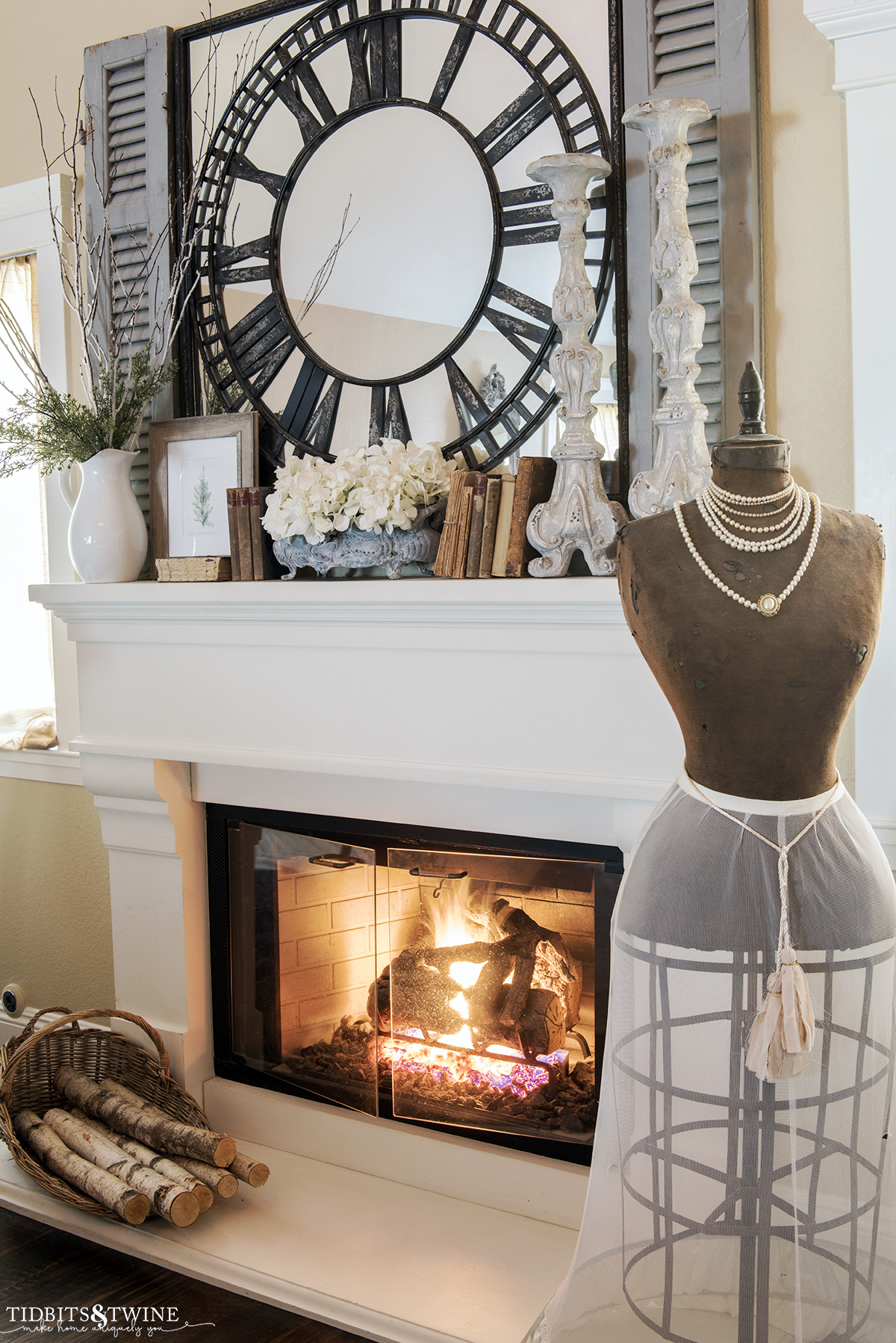 bedroom fireplace with french dress form in front of winter decorated mantel with mirror above and candlesticks and books on mantel