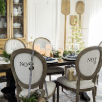 french dining room with round numbered chairs and small christmas tree in corner