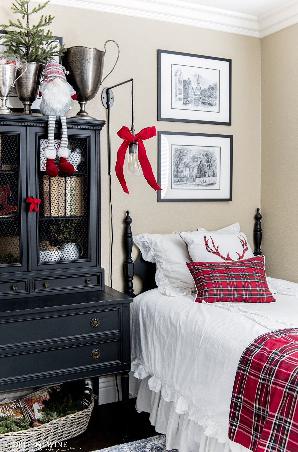 bedroom with black twin bed and white bedding decorated for christmas with red plaid and black secretary hutch on side of bed