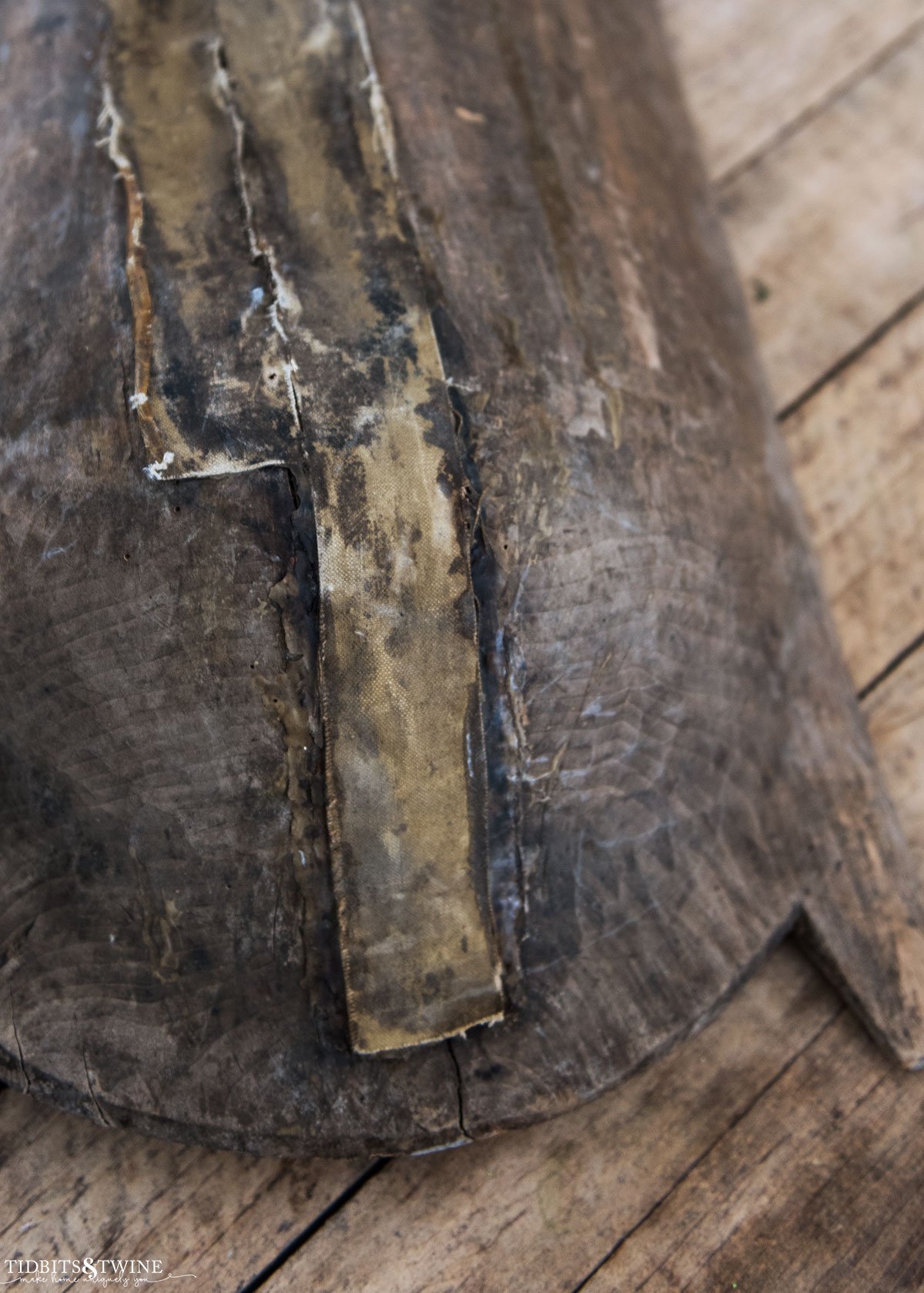 closeup bottom of antique dough bowl showing patches and repairs to cracks