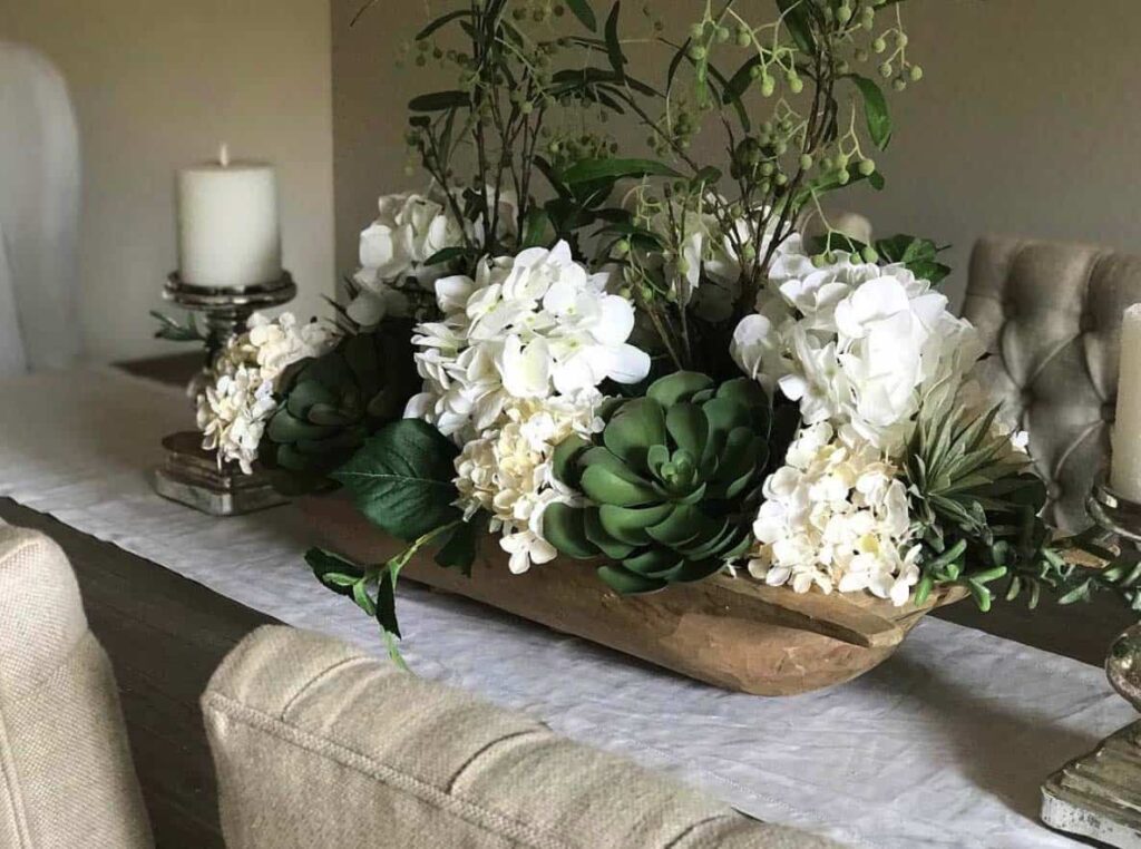 dining table centerpiece with dough bowl full of white hydrangea and succulents