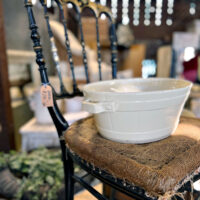 small black antique chair with burlap seat and white bowl sitting on seat