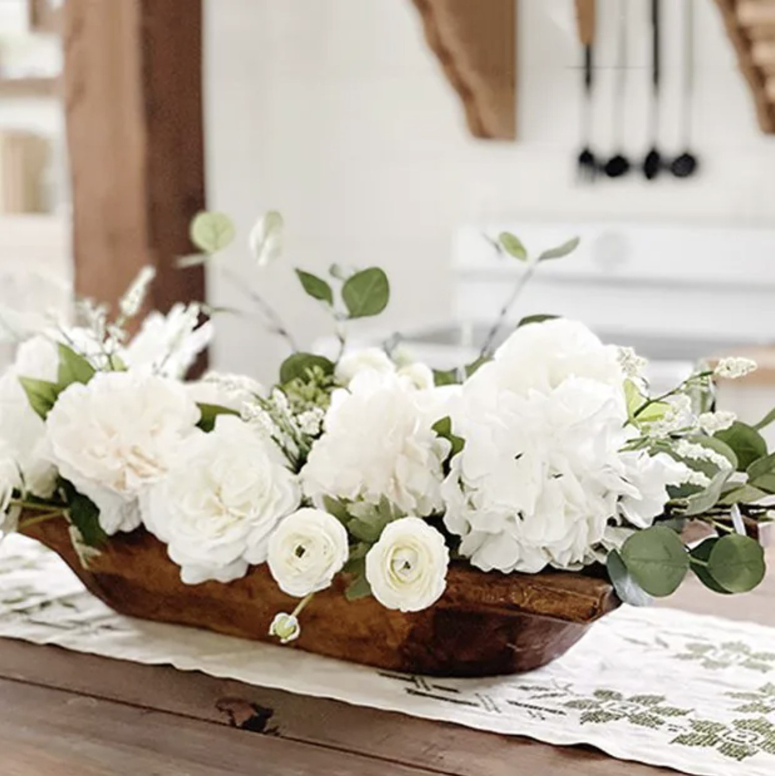 dough bowl on dining table full of why hydrangea and white peonies