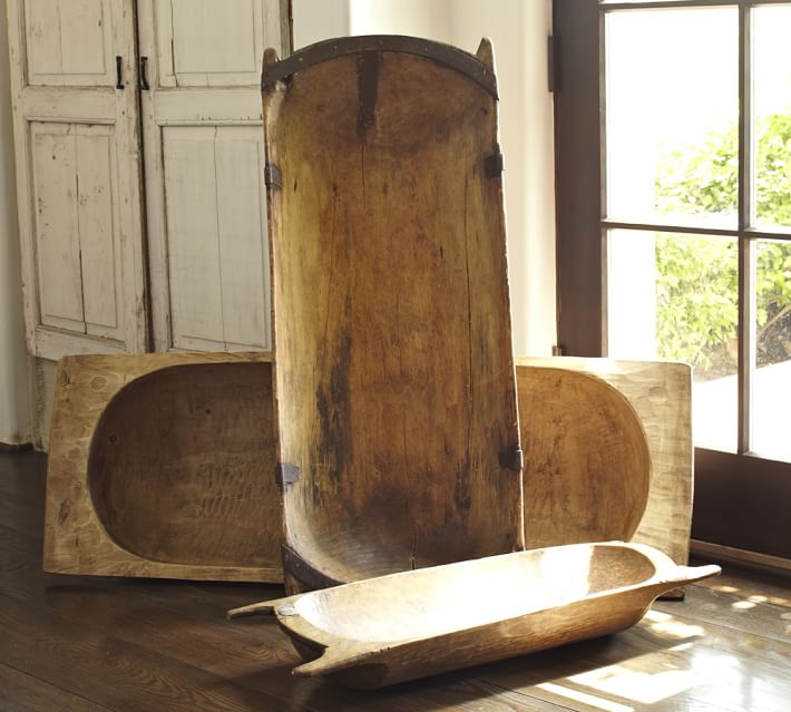 three antique dough bowls on a wooden floor next to a window