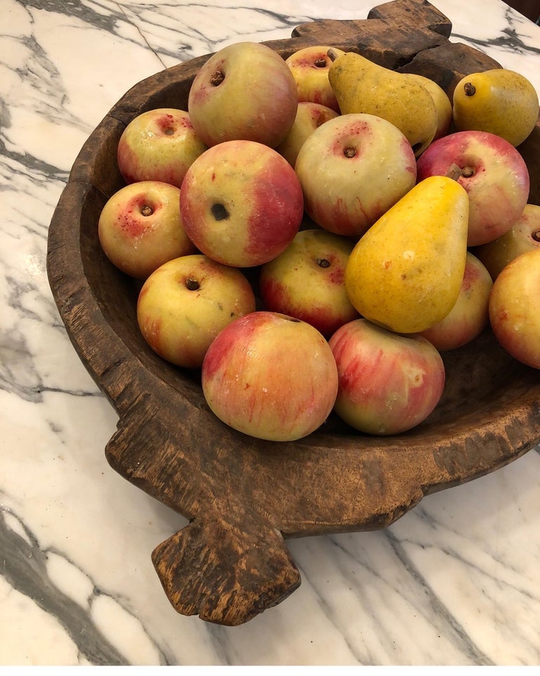 antique dough bowl on marble counter holding apples and pears