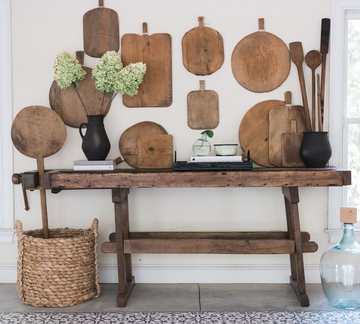 rustic console table with antique bread board display hanging above it