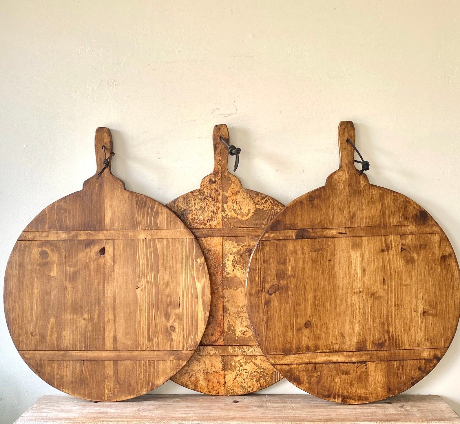 three round antique bread boards standing on a wall