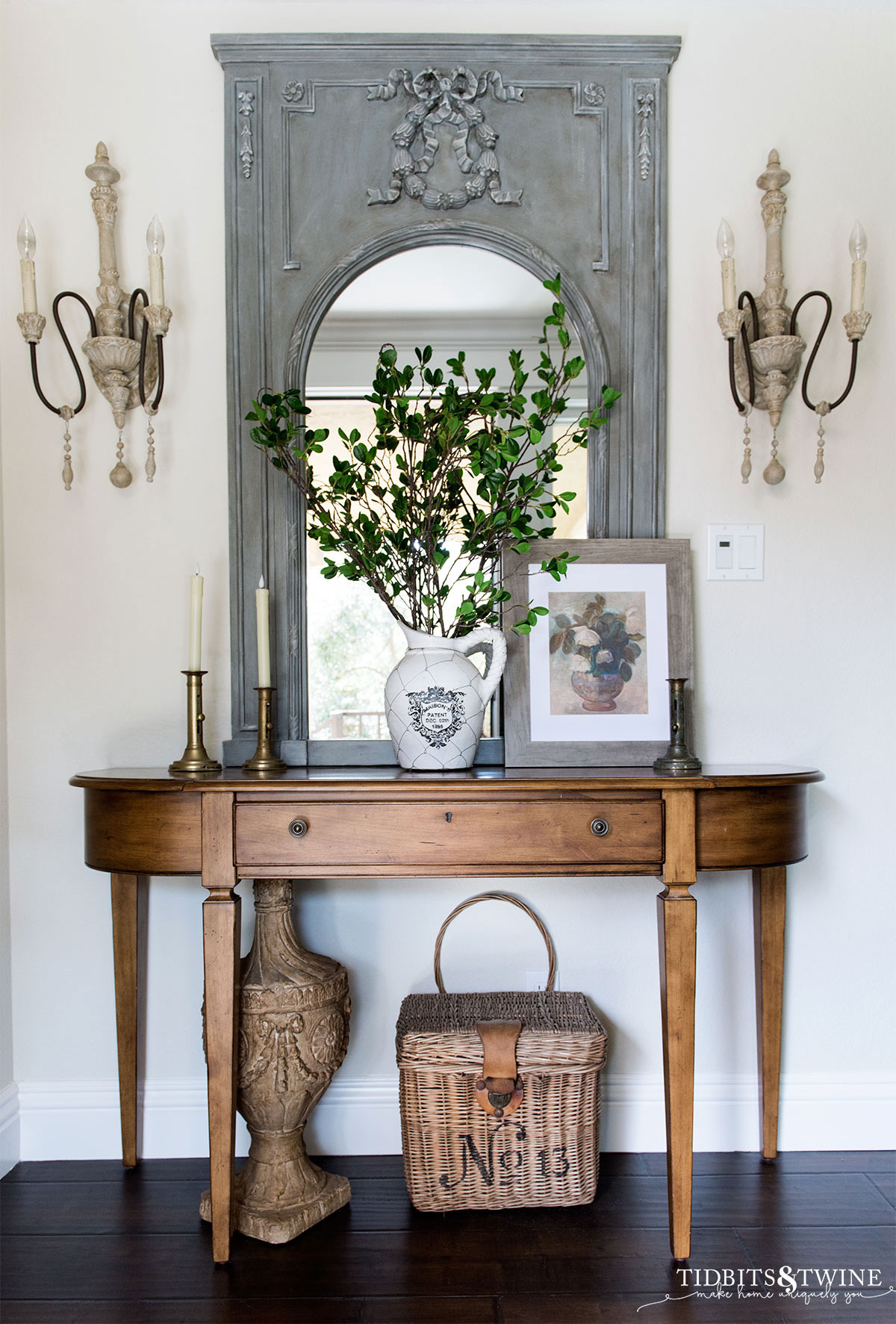 Entryway with blue trumeau mirror and demilune table decorated for Spring