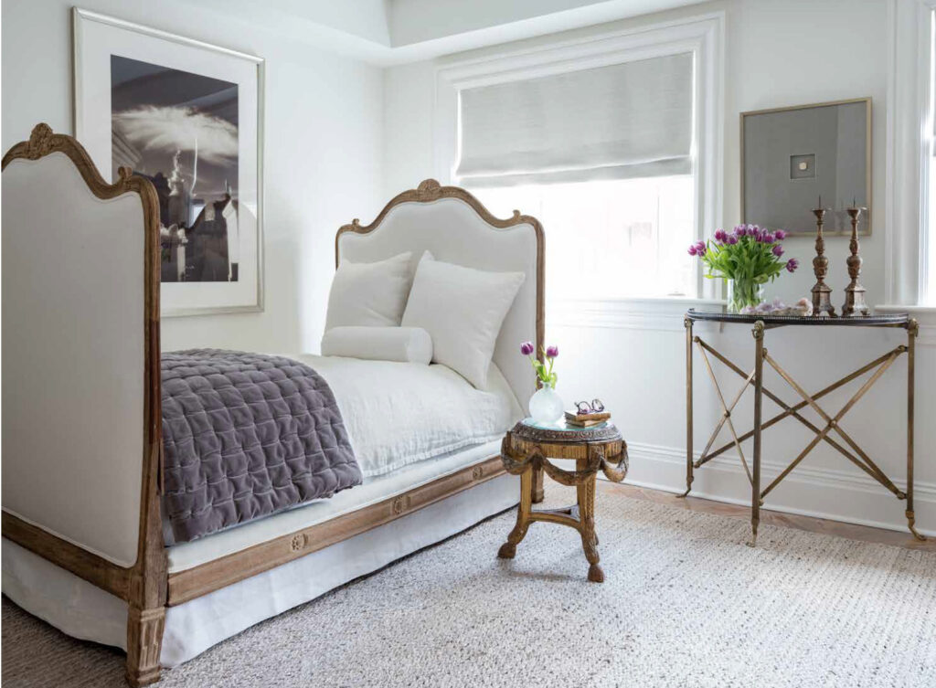 bedroom with french upholstered bed with white bedding and purple velvet quilt