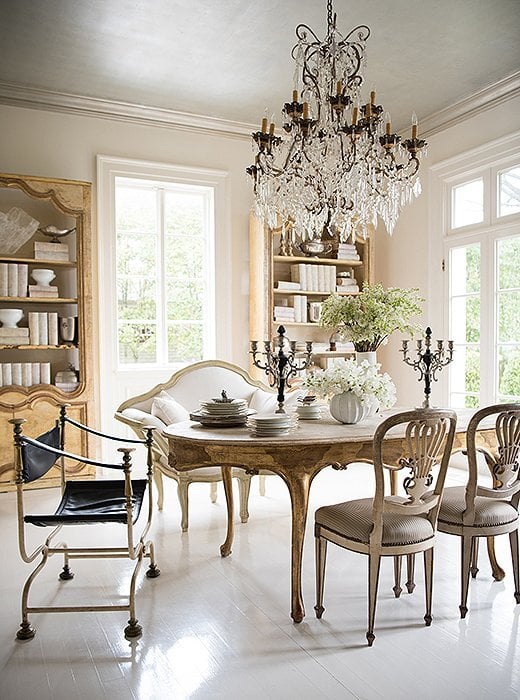 white dining room with french table and sette along with midcentury modern leather head chair