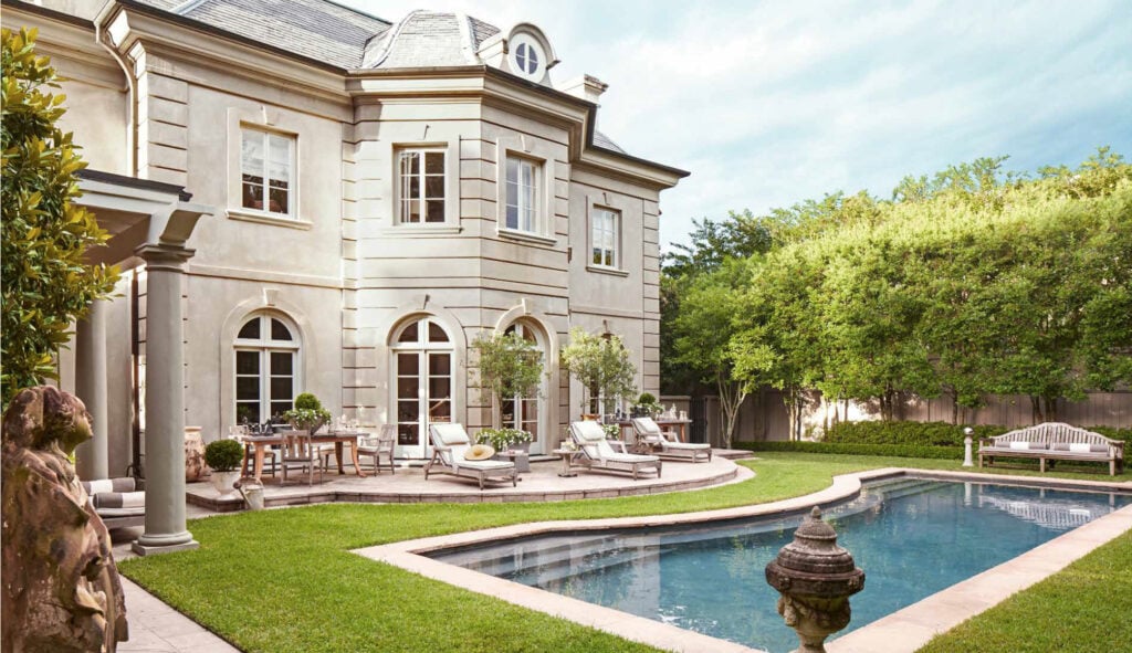 french style home backyard with pool and outdoor antique planters