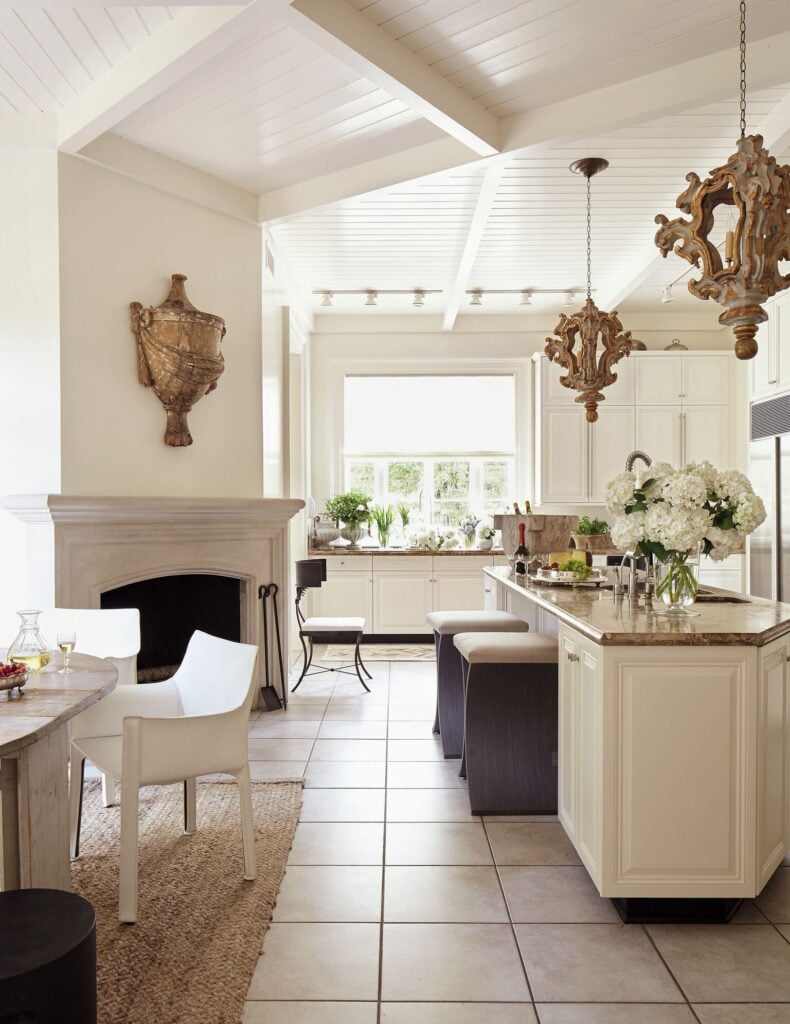 white kitchen and breakfast room with antique wood pendants above island