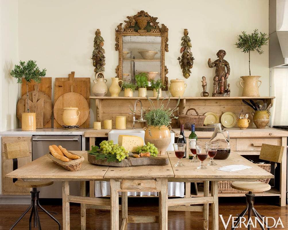 Kitchen with rustic wood cabinets and table full of yellow ceramics and antique bread boards