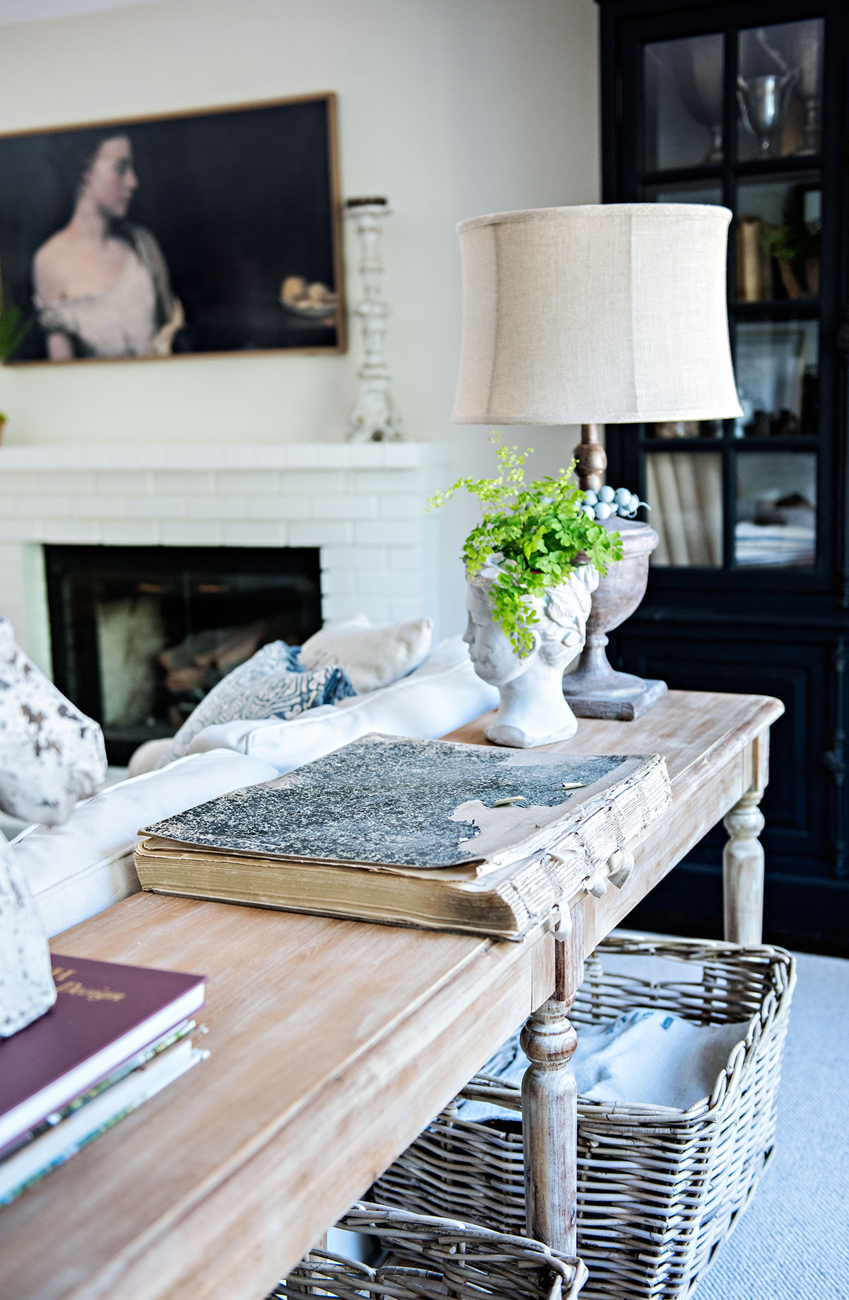 console table behind sofa with lamp and goddess head planter in family room