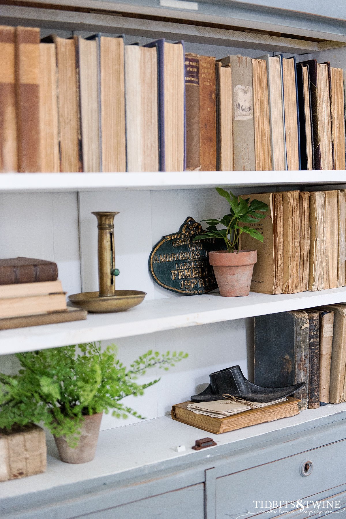 antique french blue cabinet styled with books and small plants for spring