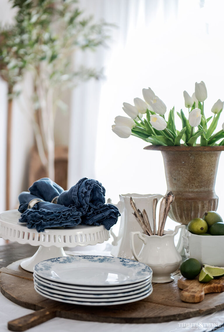 dining table vignette with white ironstone dishes and urn with white tulips