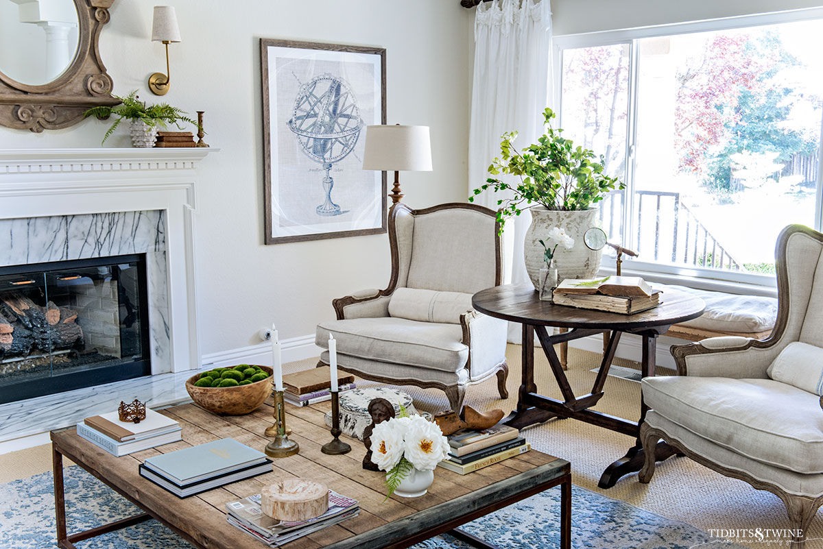 french living room with wingback chairs and industrial coffee table and fireplace for spring