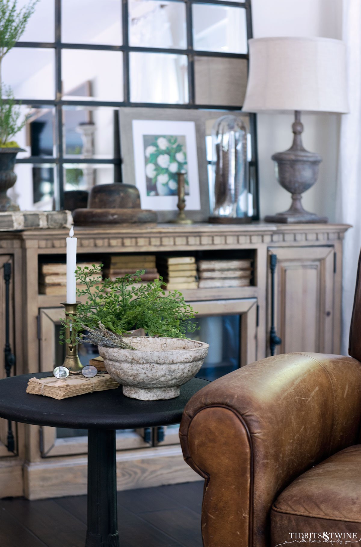 family room with leather chair and metal bistro table net to it and decorated console in background