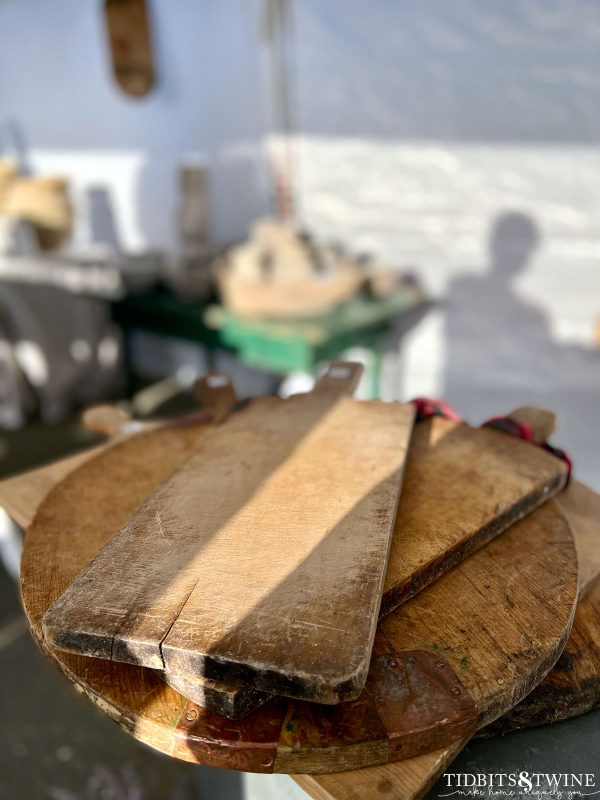 stack of antique european bread boards on display at antique fair