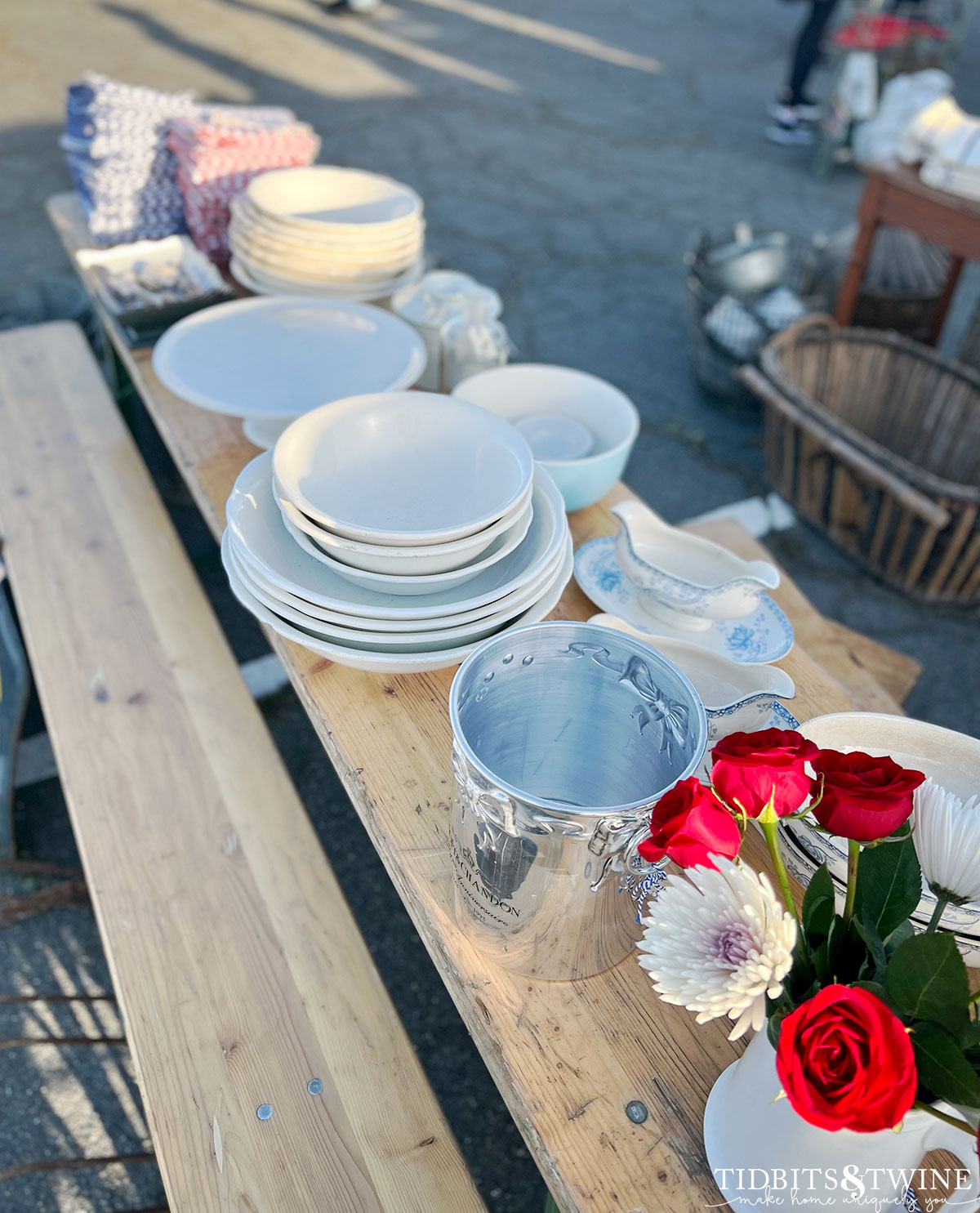white antique dishes on beer garden table with silver champagne bucket and red roses