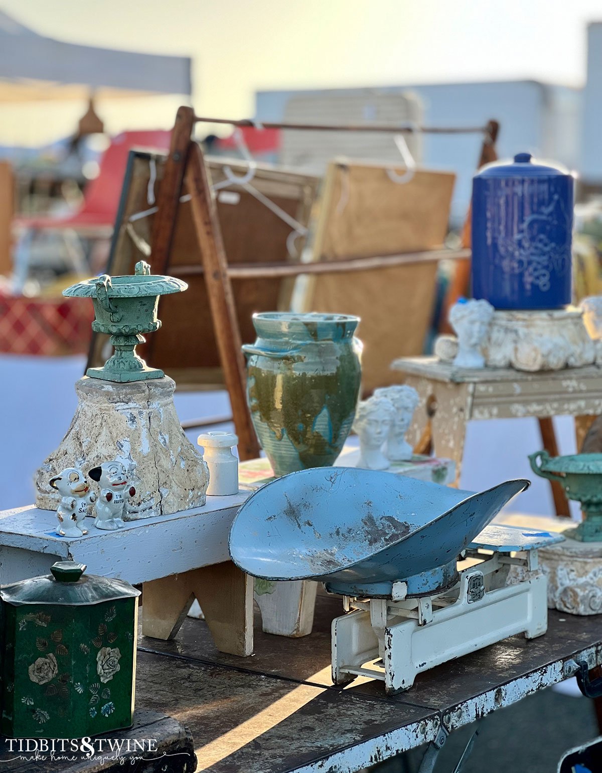 vintage scale with glazed crocks and green urn on table at antique fair