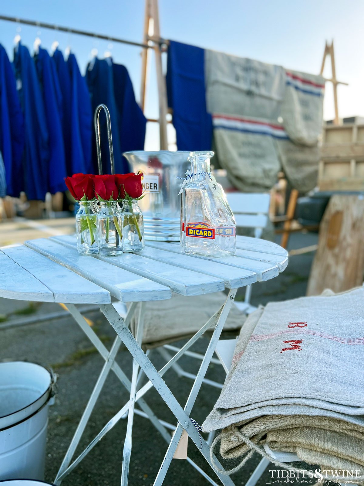 white bistro table with champagne bucket and red roses on top