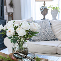 spring dough bowl on coffee table next to bouquet of white flowers in family room