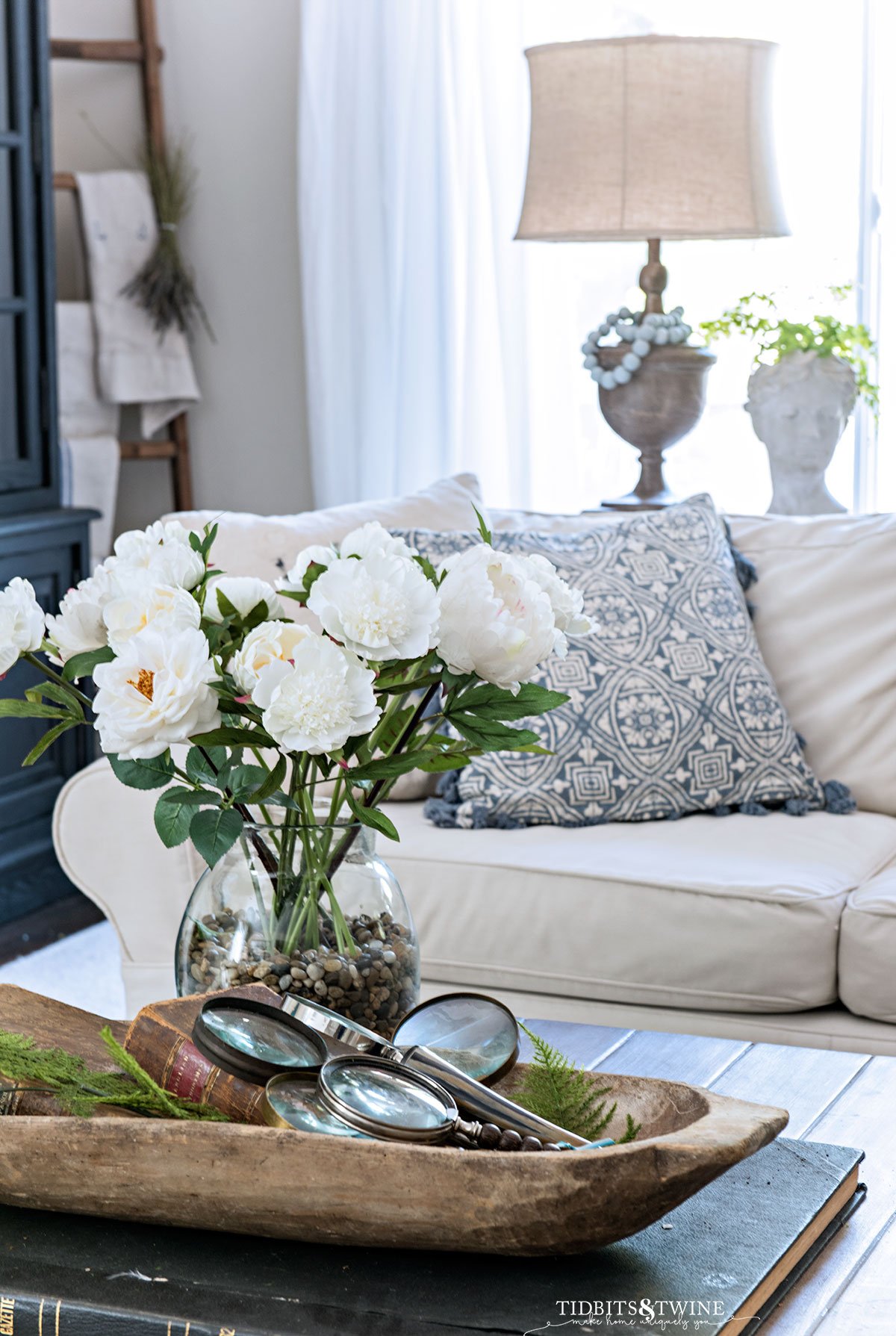 spring dough bowl on coffee table next to bouquet of white flowers in family room