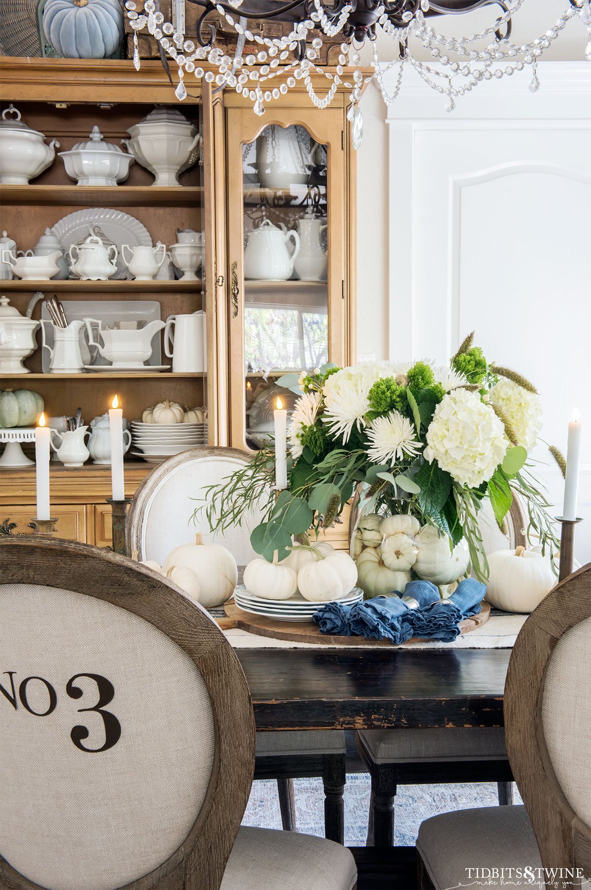 dining room set for Fall with green and white flower arrangement centerpiece with white pumpkin vase filler